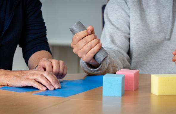 A person holding a grey cylindrical object