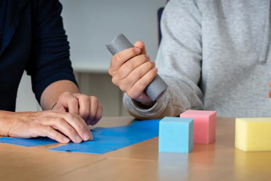 A person holding a grey cylindrical object
