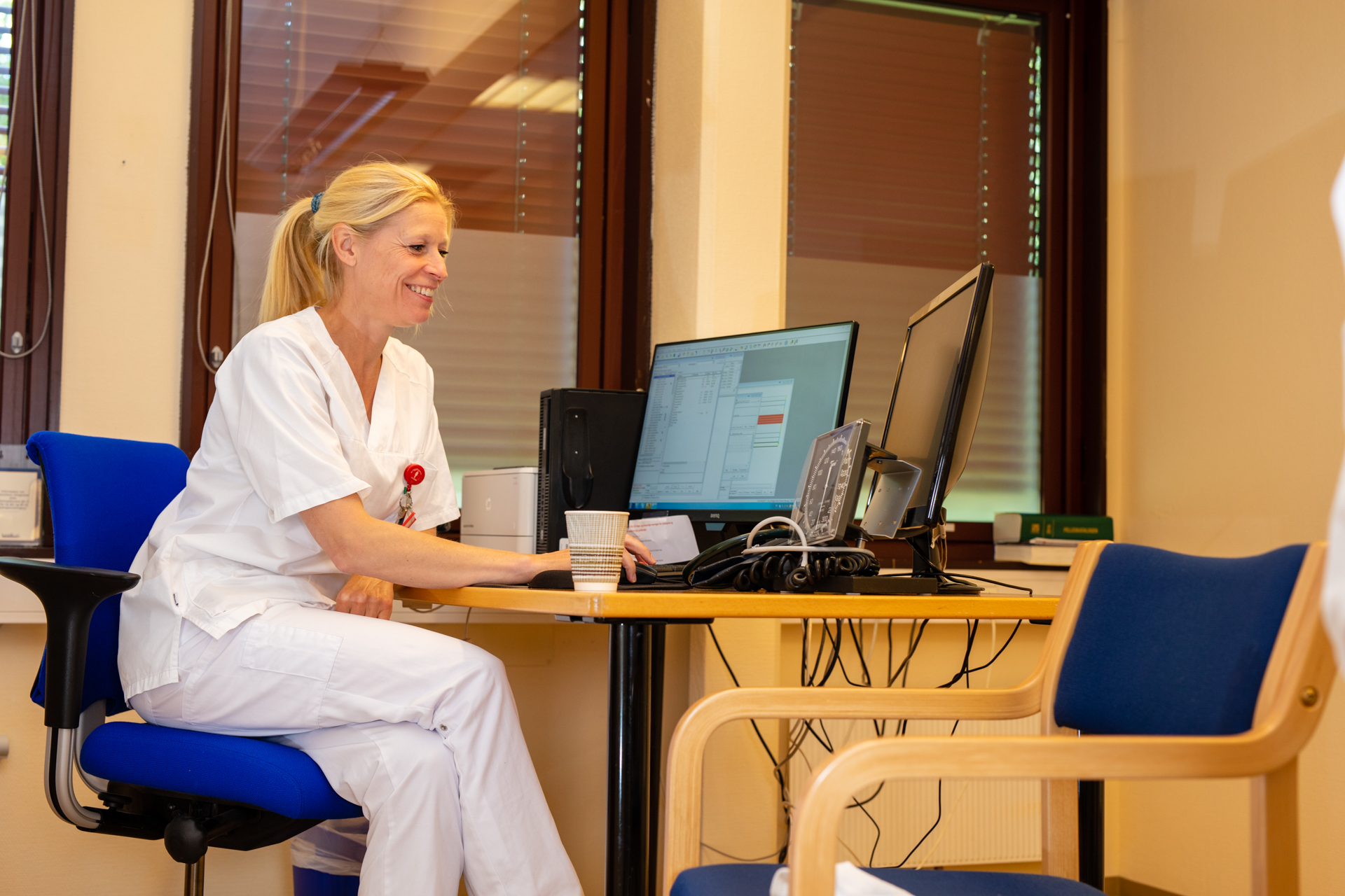 En person som sitter ved et skrivebord med en datamaskin